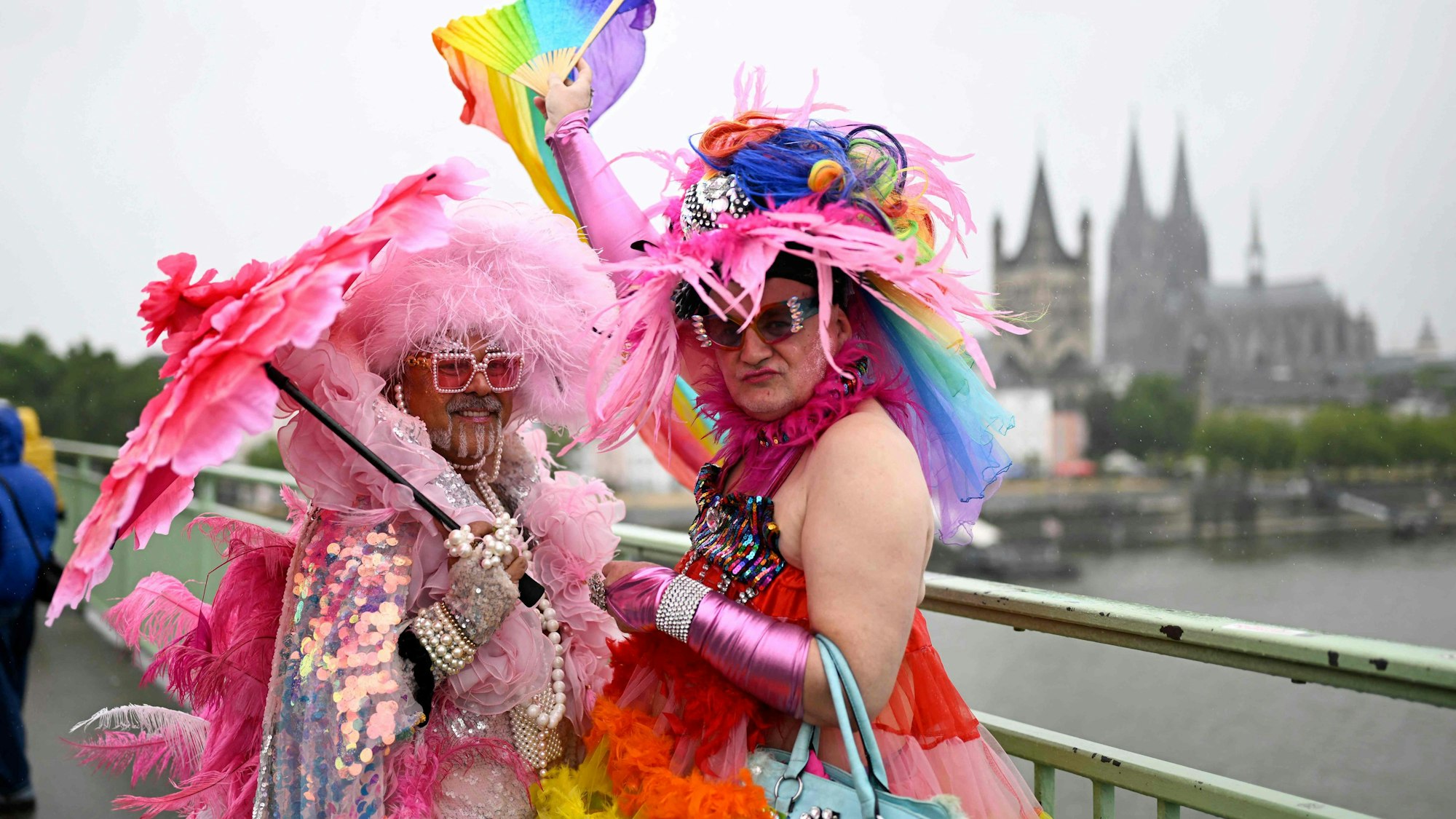 Prächtig geschmückt sind diese beiden CSD-Feiernden auf der Deutzer Brücke unterwegs. Regen? Egal.