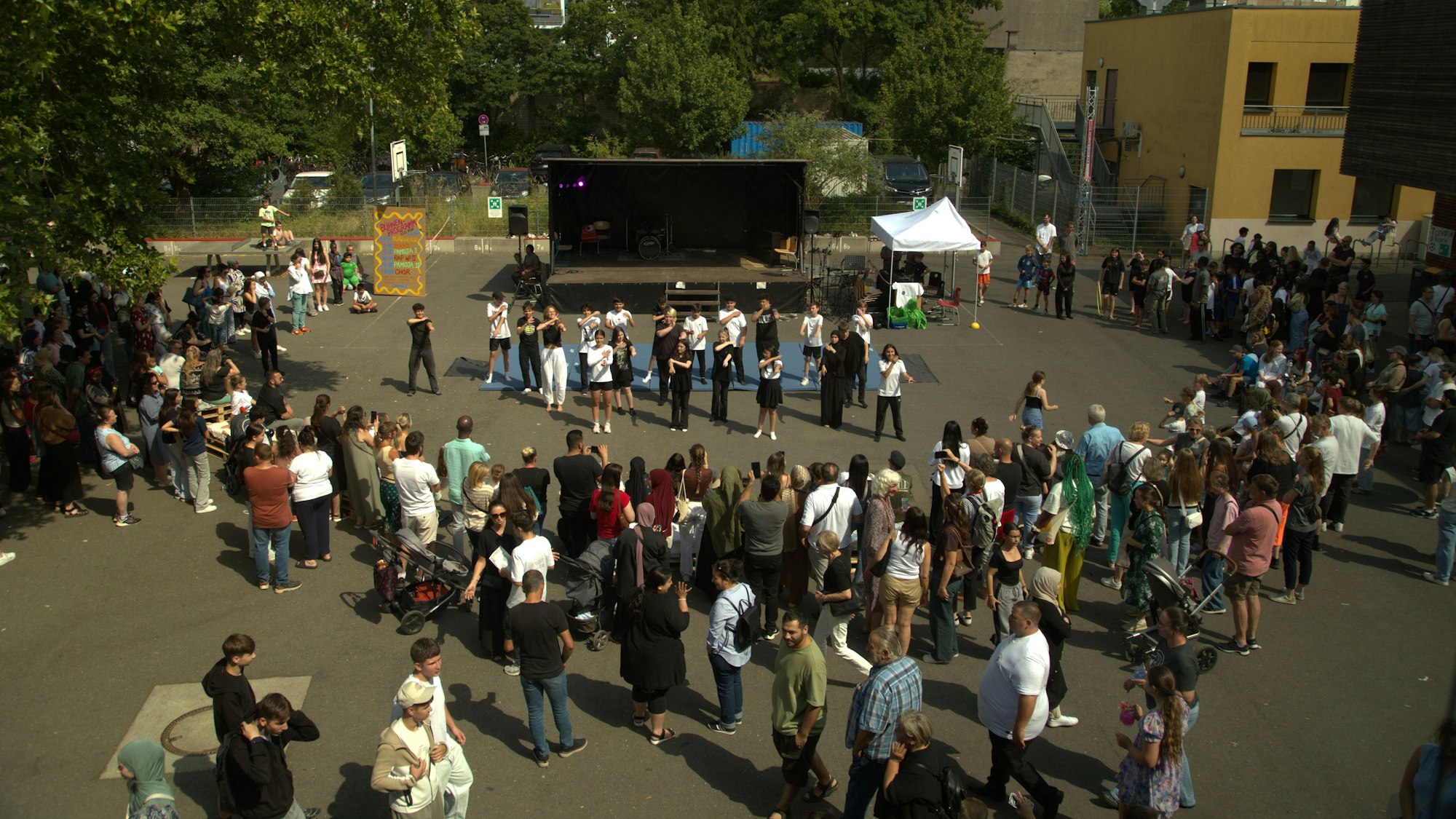 Schüler und Lehrer stehen versammelt auf dem Schulfhof der Peter-Ustinov-Realschule in Nippes, anlässlich des 125-jähriges Bestehens.