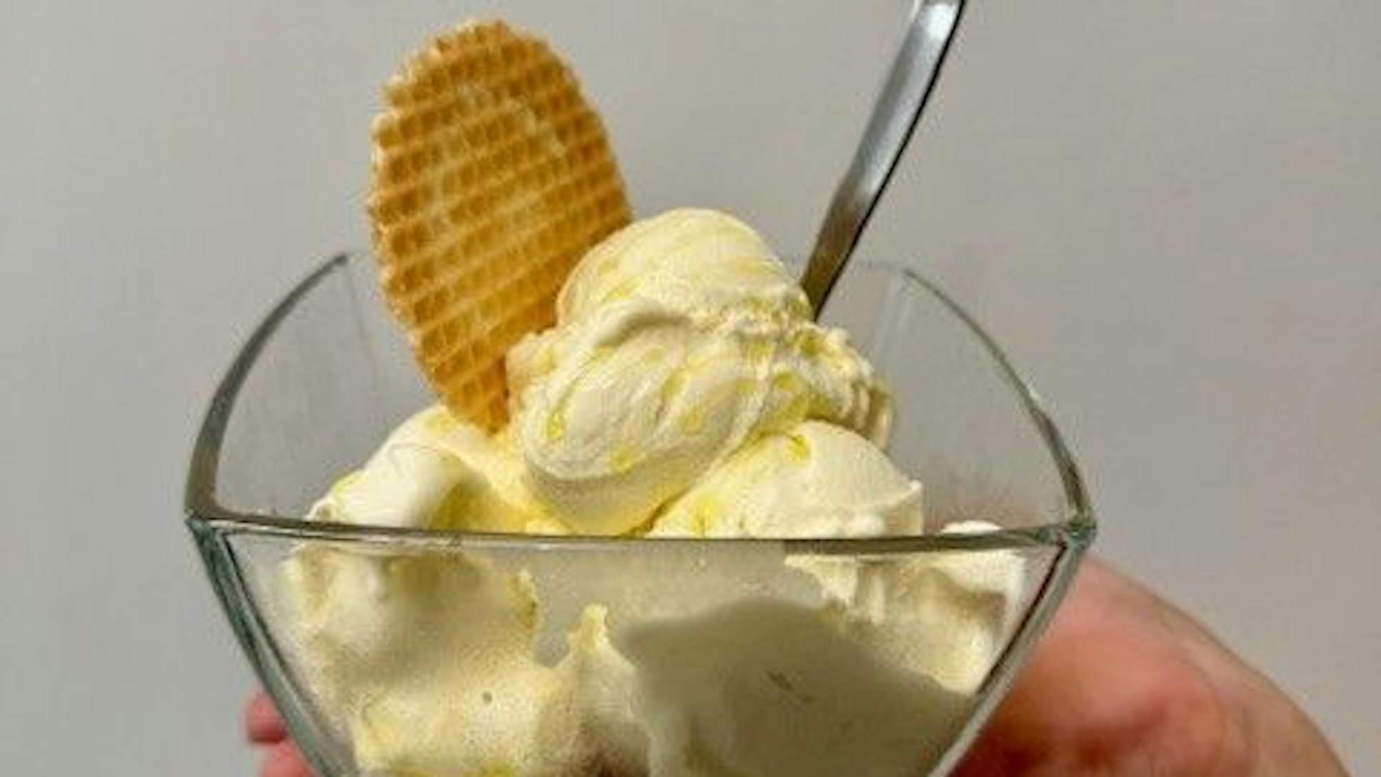 Mehrere Kugeln Eis in einer Glasschale, mit Olivenöl beträufelt