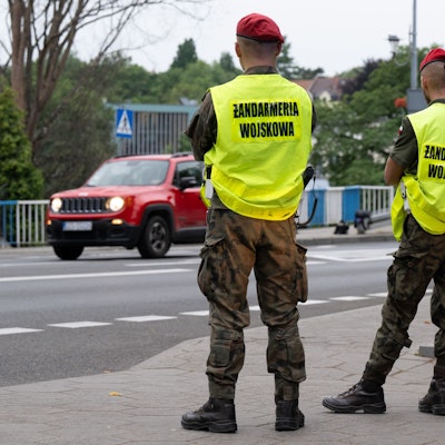 Das Bild zeigt polnische Grenzschützer auf der polnischen Seite hinter der Stadtbrücke von Görlitz, die den Verkehr beobachten. Foto: Sebastian Kahnert/dpa