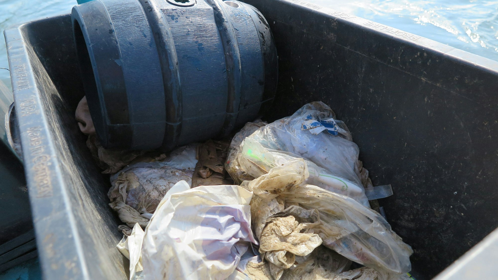 Das Bild zeigt ein Fass und Plastikmüll, den die Rheinkrake gefiltert hat.