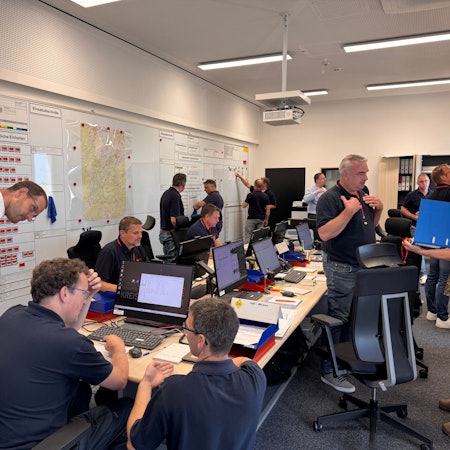 Menschen arbeiten und besprechen sich im Lagezentrum des Kreises Euskirchen.