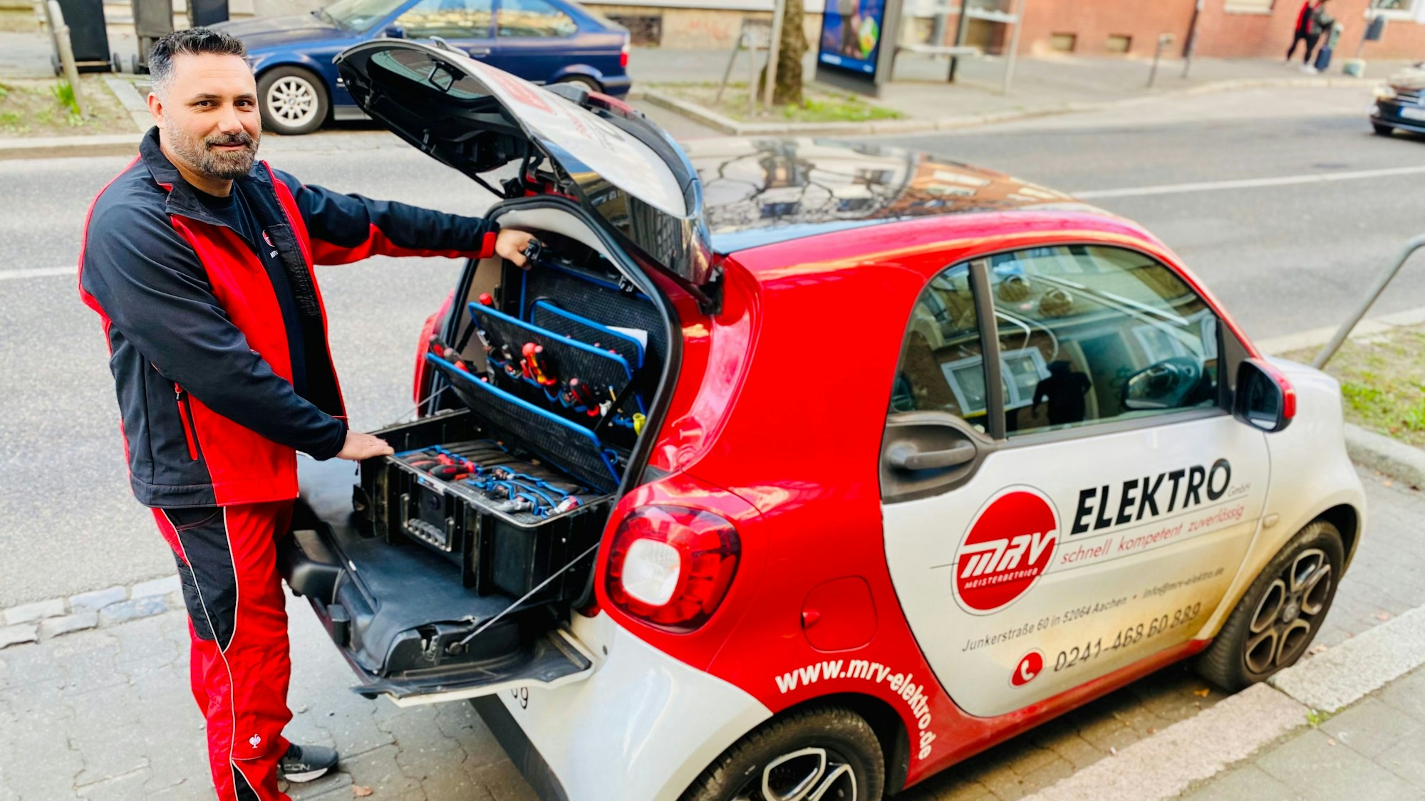 Elektrotechnikermeister Mersim Mrvoljak steht an seinem Fahrzeug.