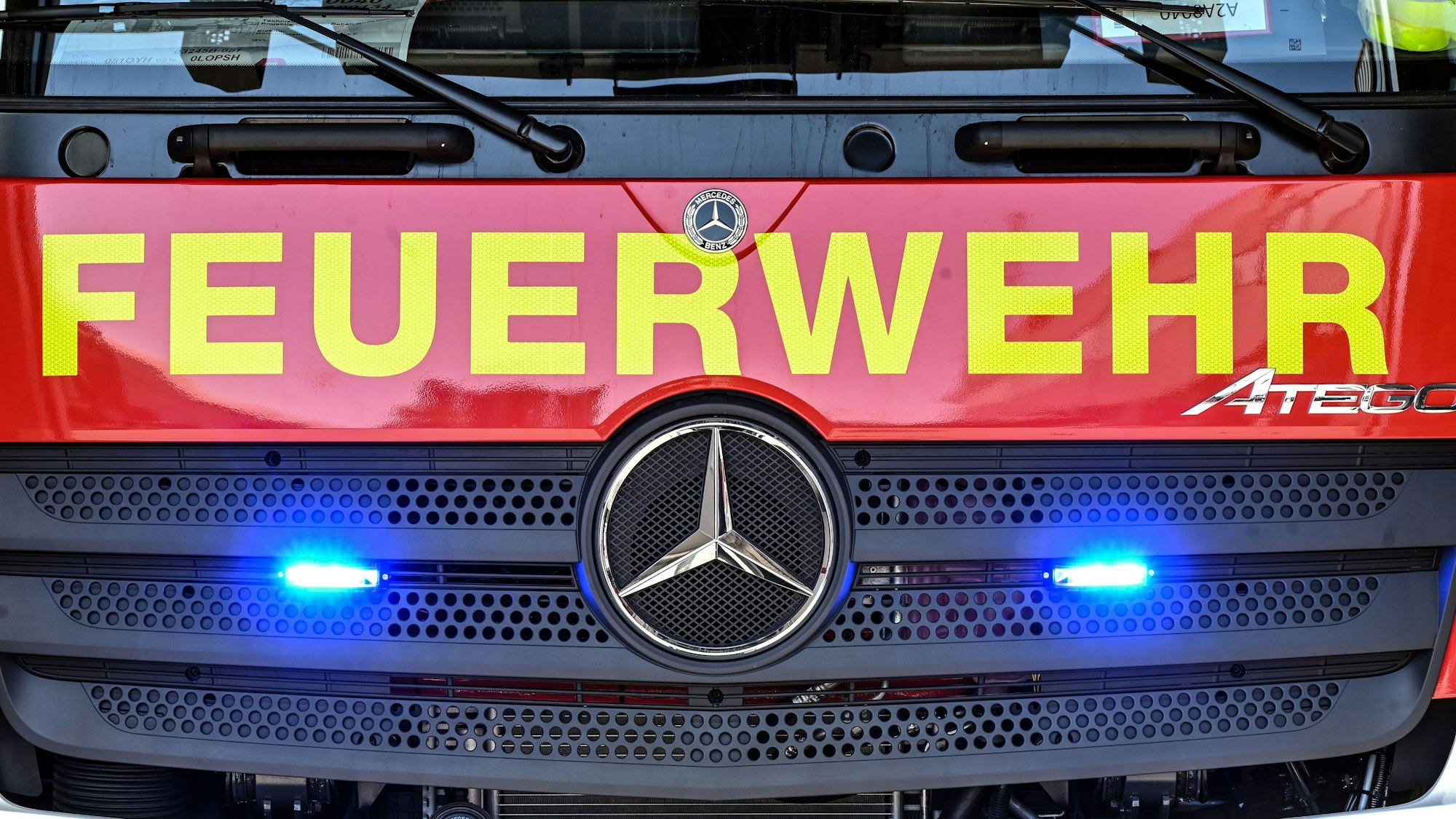 : An einem Feuerwehrfahrzeug leuchten unter dem Schriftzug „Feuerwehr“ zwei Blaulichter.