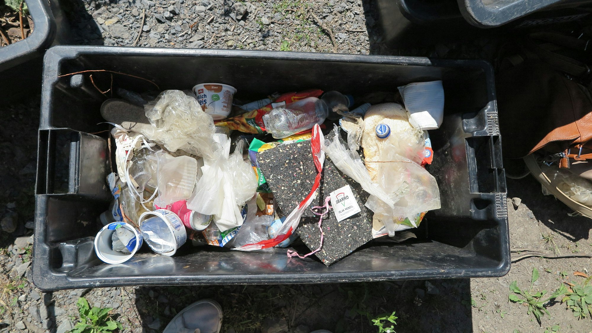 Das Bild zeigt einen Eimer mit angespültem Müll.