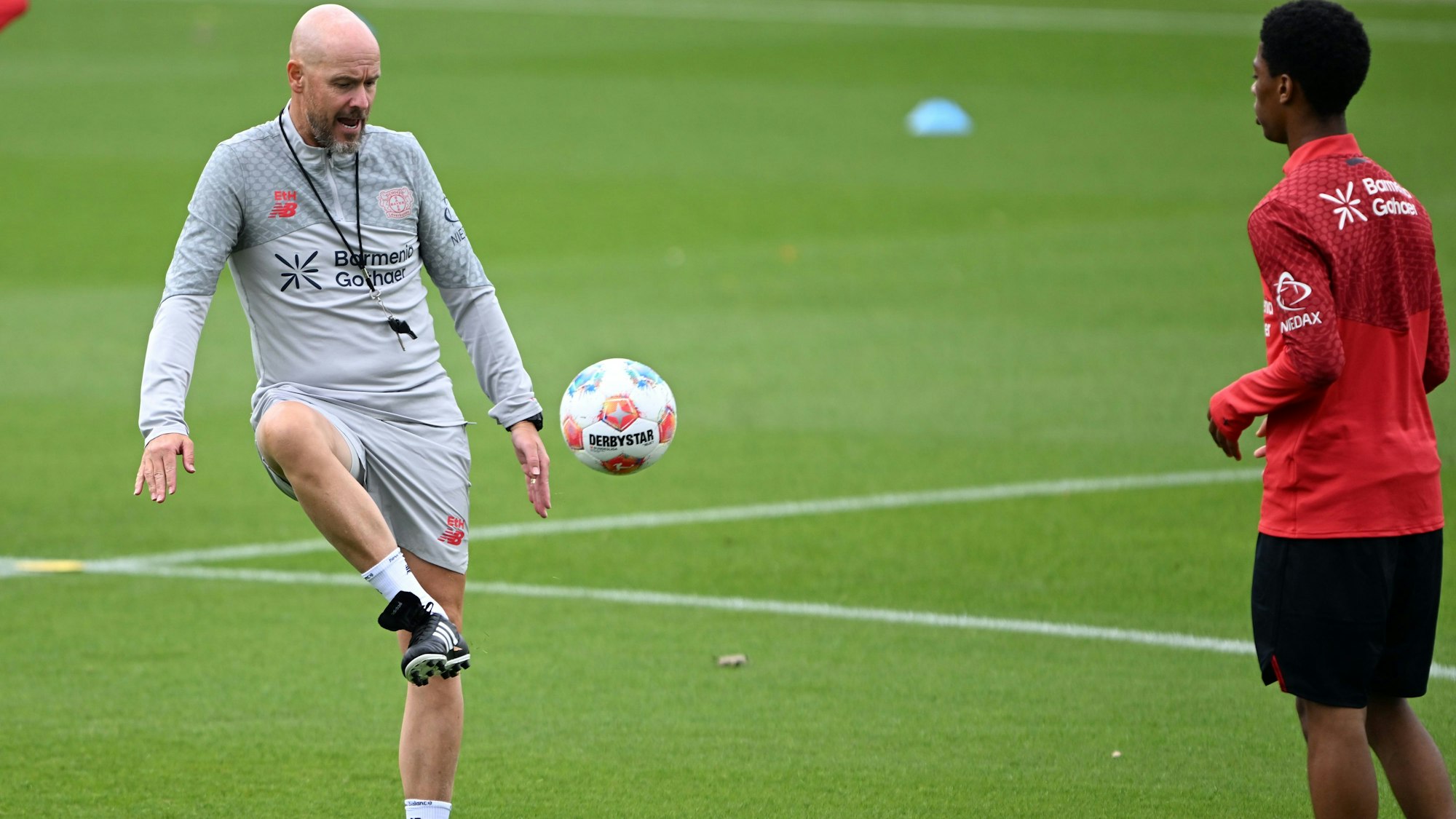 Bayer Leverkusens neuer Cheftrainer Erik ten Hag (l) spielt den Ball während seiner ersten Trainingseinheit