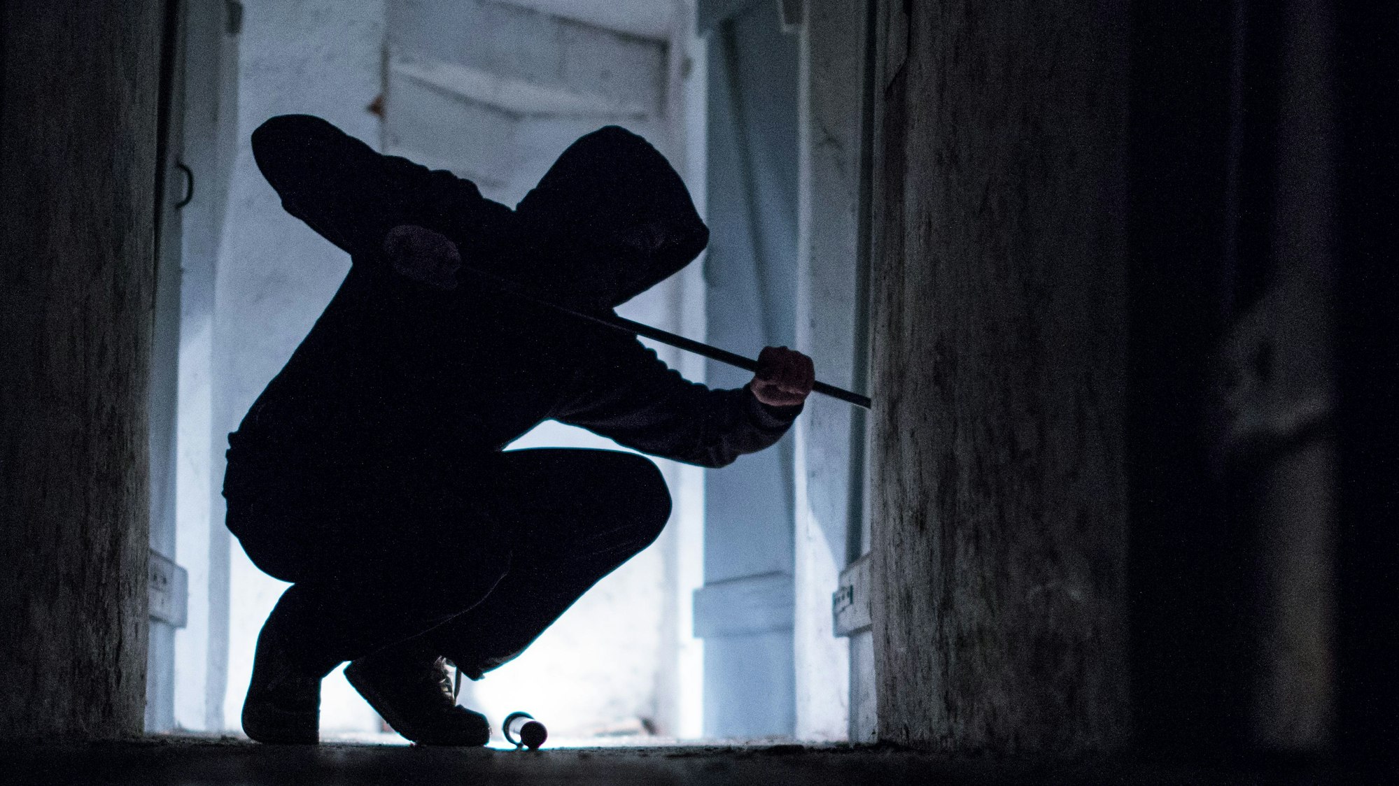 „“Ein Einbrecher hebelt mit einem Brecheisen eine Tür im Keller eines Wohnhauses auf (gestellte Szene).