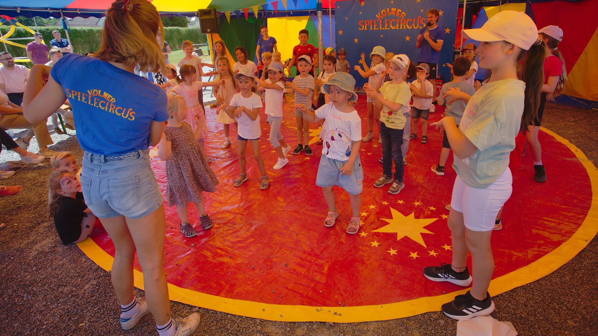 Das Foto zeigt Kinder in der Zirkusmanege.