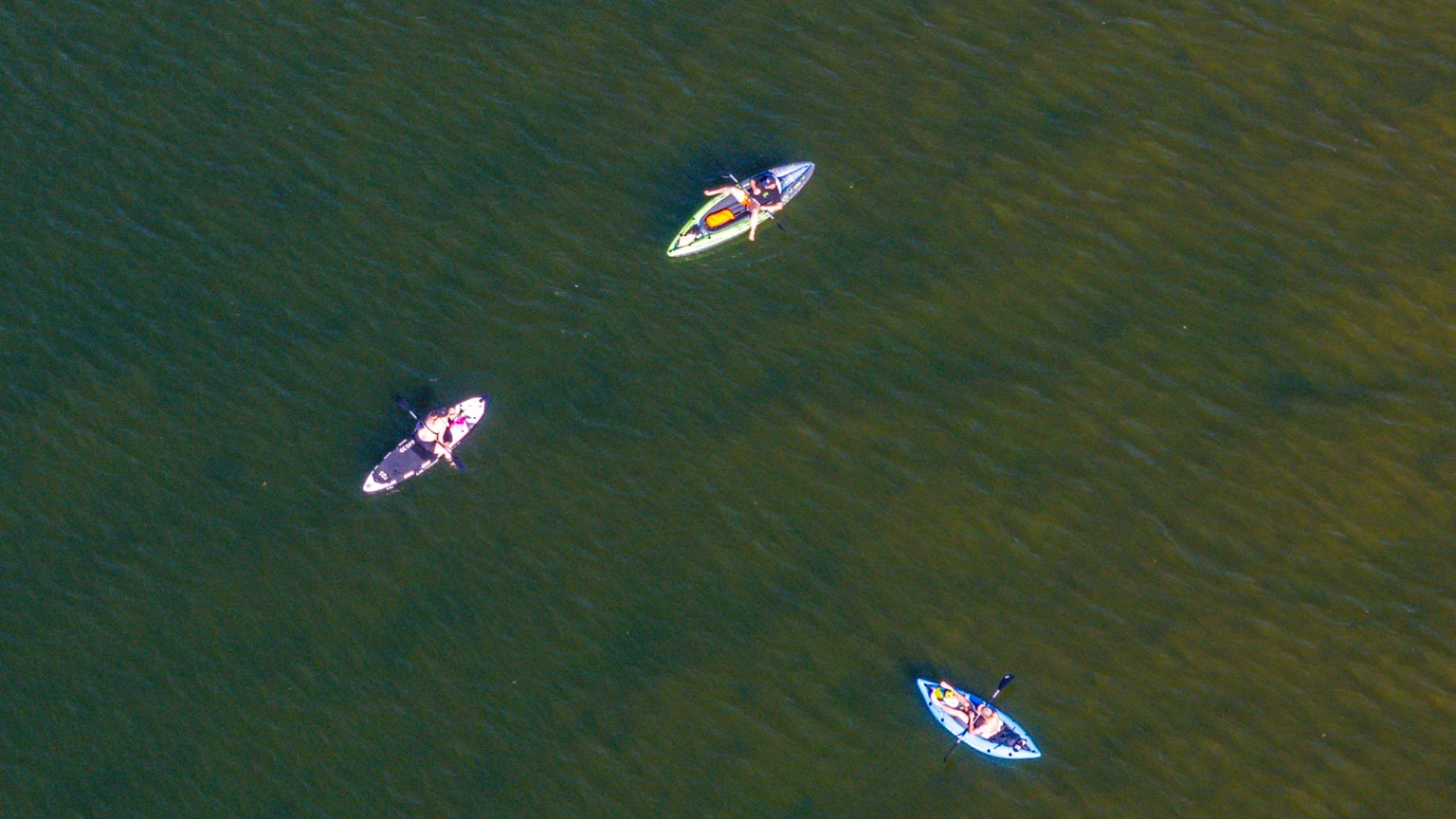 Paddelbootfahrer erfrischen sich auf einem See, sie sind in einer Luftaufnahme zu sehen.