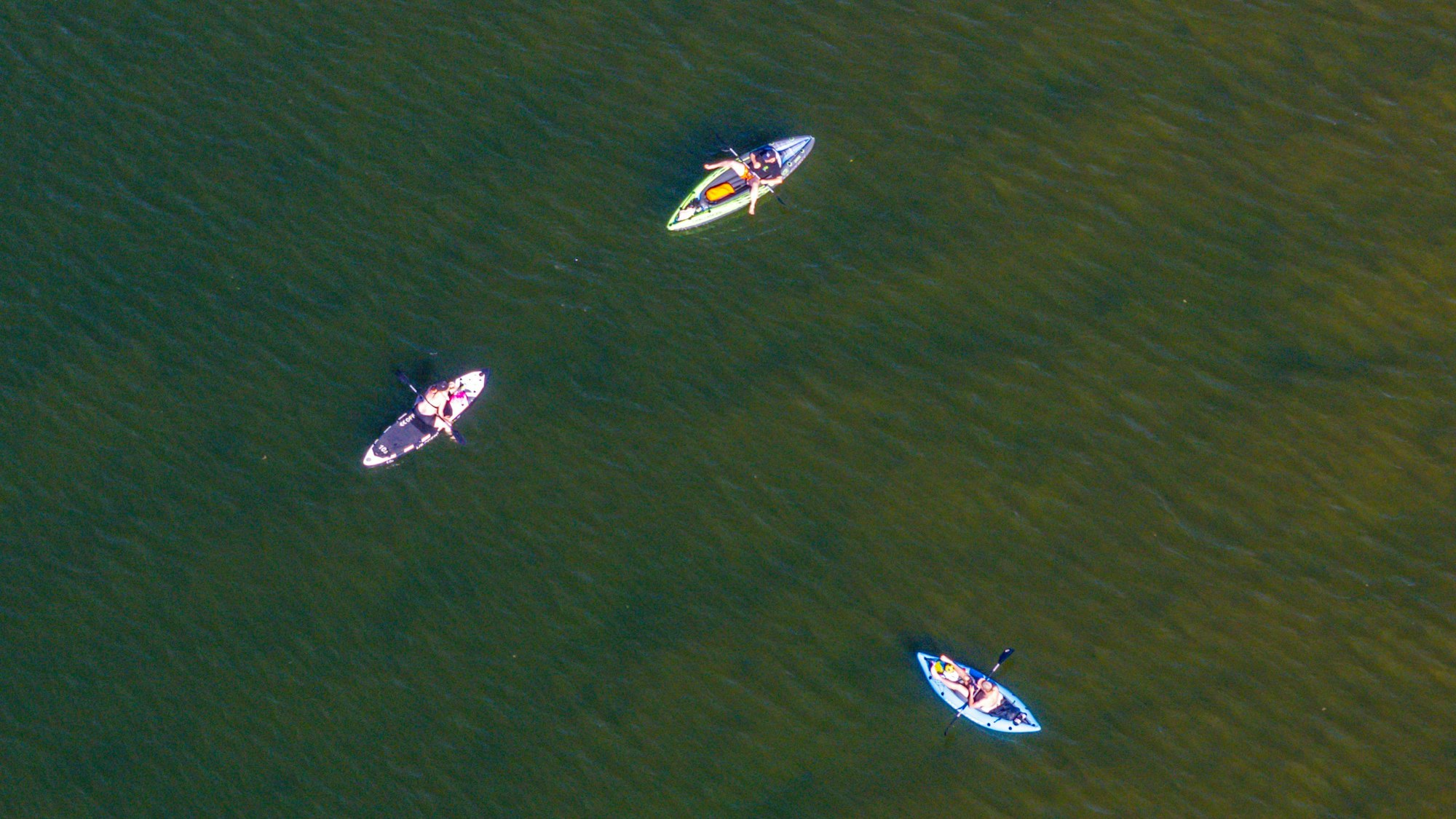 Paddelbootfahrer erfrischen sich auf einem See, sie sind in einer Luftaufnahme zu sehen.