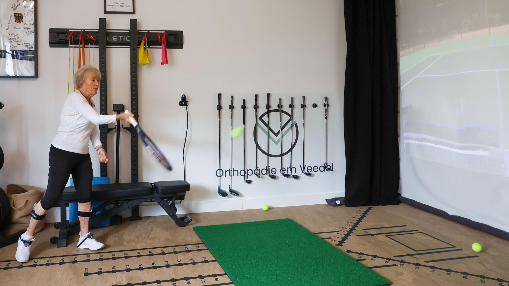 Doris Pöttgen schlägt im Sportslab mit einem Tennisschläger Bälle an die Wand.