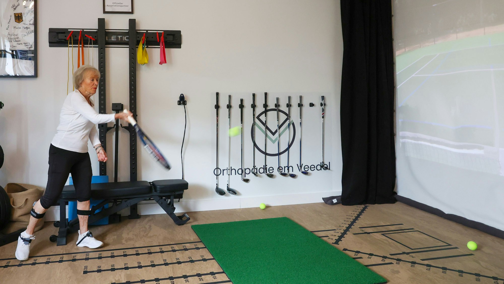 Doris Pöttgen schlägt im Sportslab mit einem Tennisschläger Bälle an die Wand.