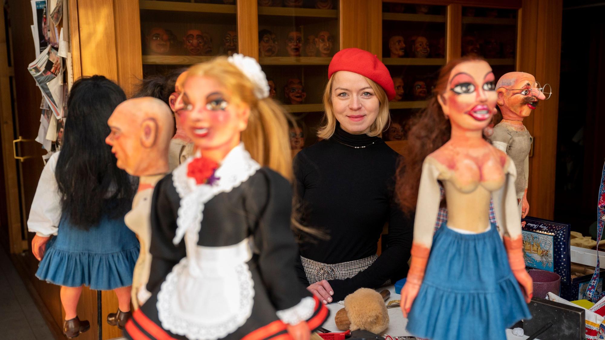 Mareike Marx ist inmitten von Marionetten zu sehen.
