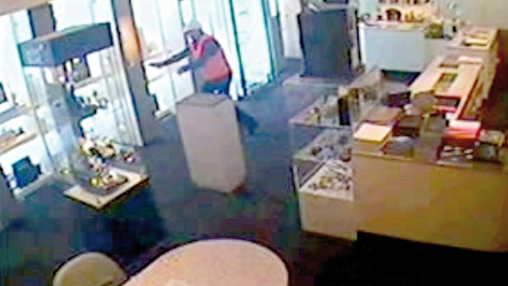 Der Räuber 2011 mit Helm und Warnweste bei der Tatausführung im Juweliergeschäft