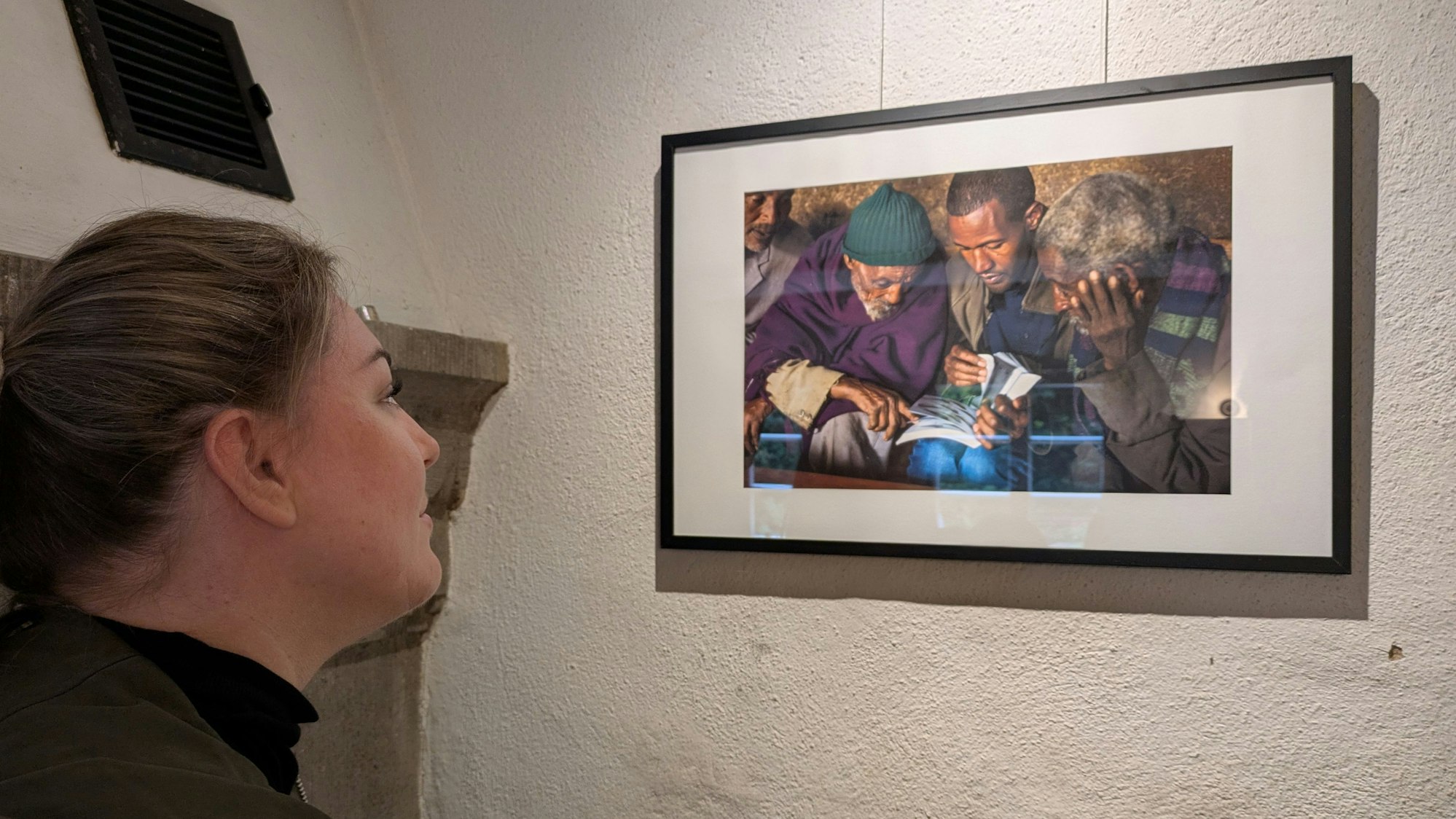 Eine Frau betrachtet eine Fotografie in einer Ausstellung