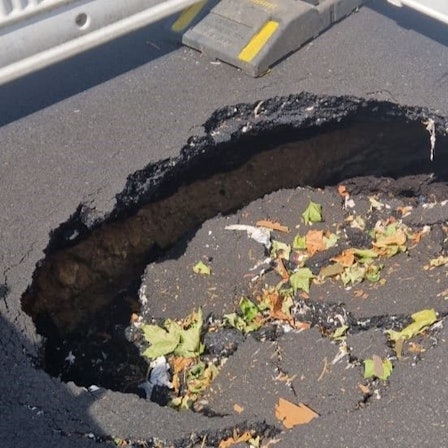 Auf der Adenauerallee in Bonn klafft ein riesiges Loch in der Fahrbahn.