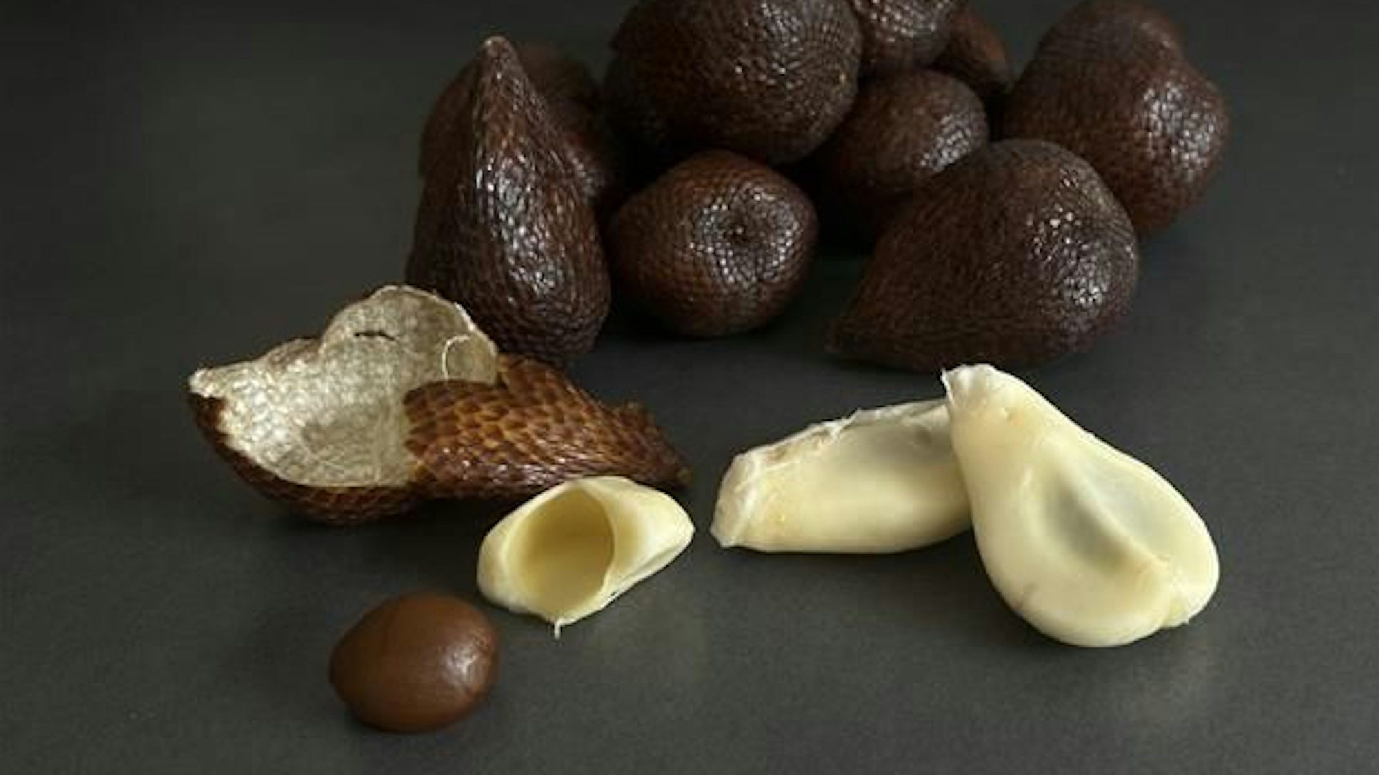 Geschlossene und geöffnete Früchte. Die Schale der Frucht sieht aus wie die Haut einer Schlange.