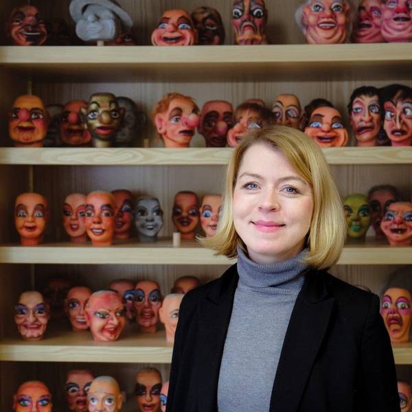 Frau Marx ist vor einem Regal mit Puppenköpfen im Porträt zu sehen.