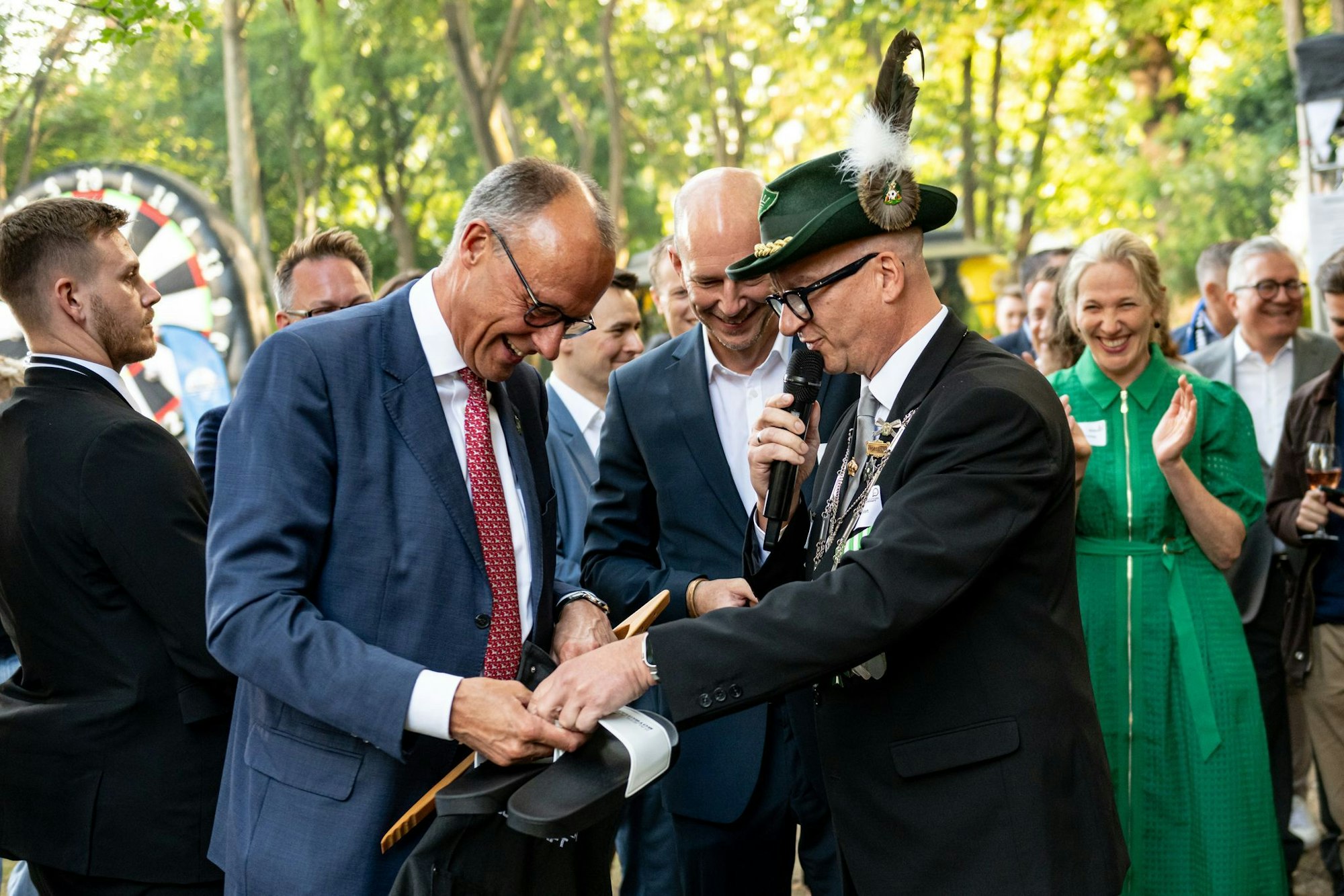 Bundeskanzler Friedrich Merz (CDU) bekommt beim Schützenfest der Sauerländer Botschaft Badeschlappen mit der Aufschrift «Rambo Zambo» geschenkt.