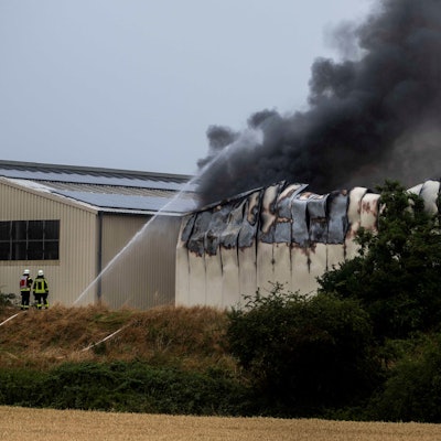 Schwarzer Rauch steigt aus einer Halle.