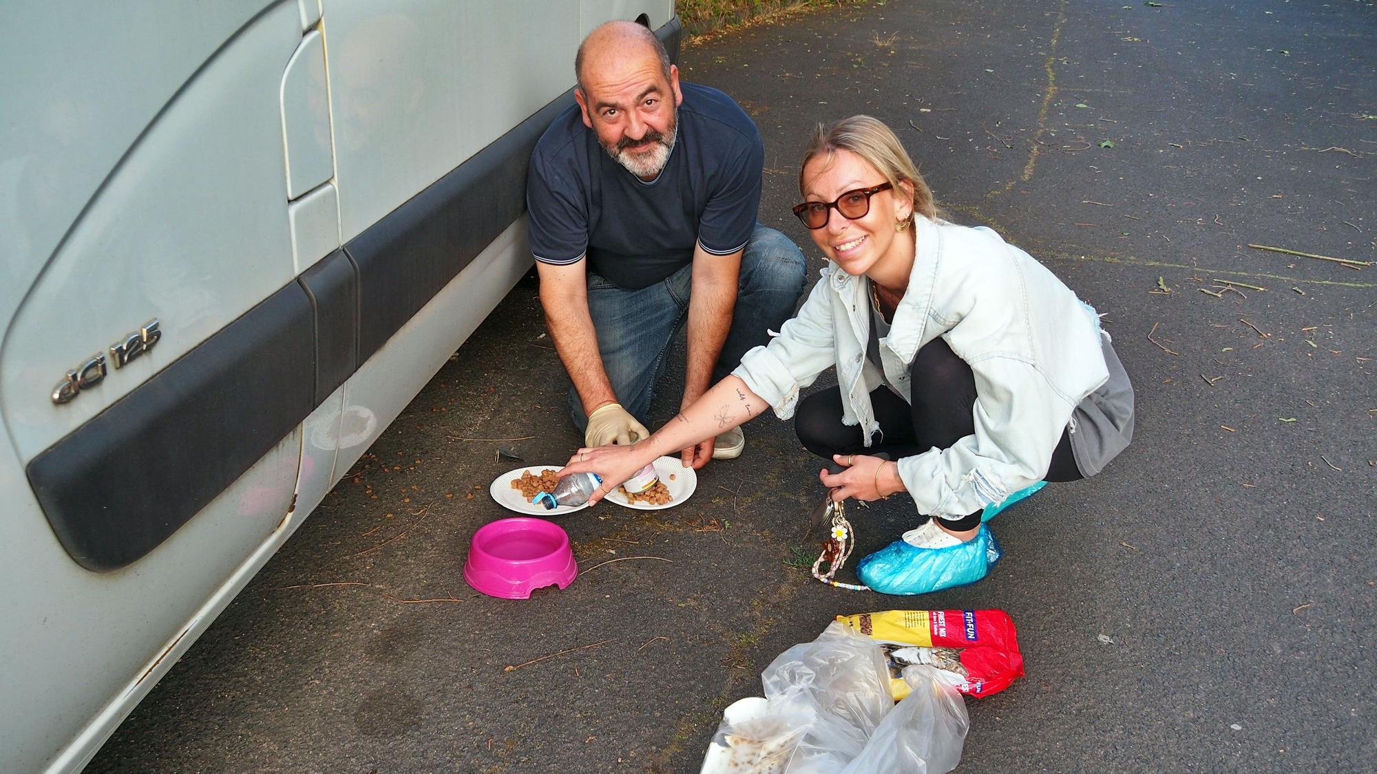 Ein Mann und eine Frau füllen Futter in Näpfe.