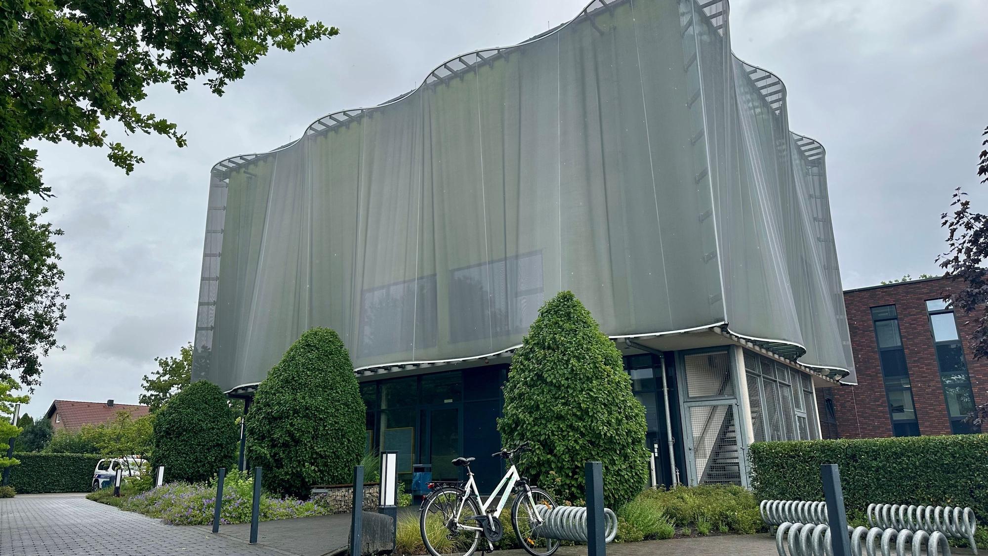 Zu sehen ist ein Gebäude, das wirkt, als wäre es von einem grauen eisernen Umhang verdeckt.