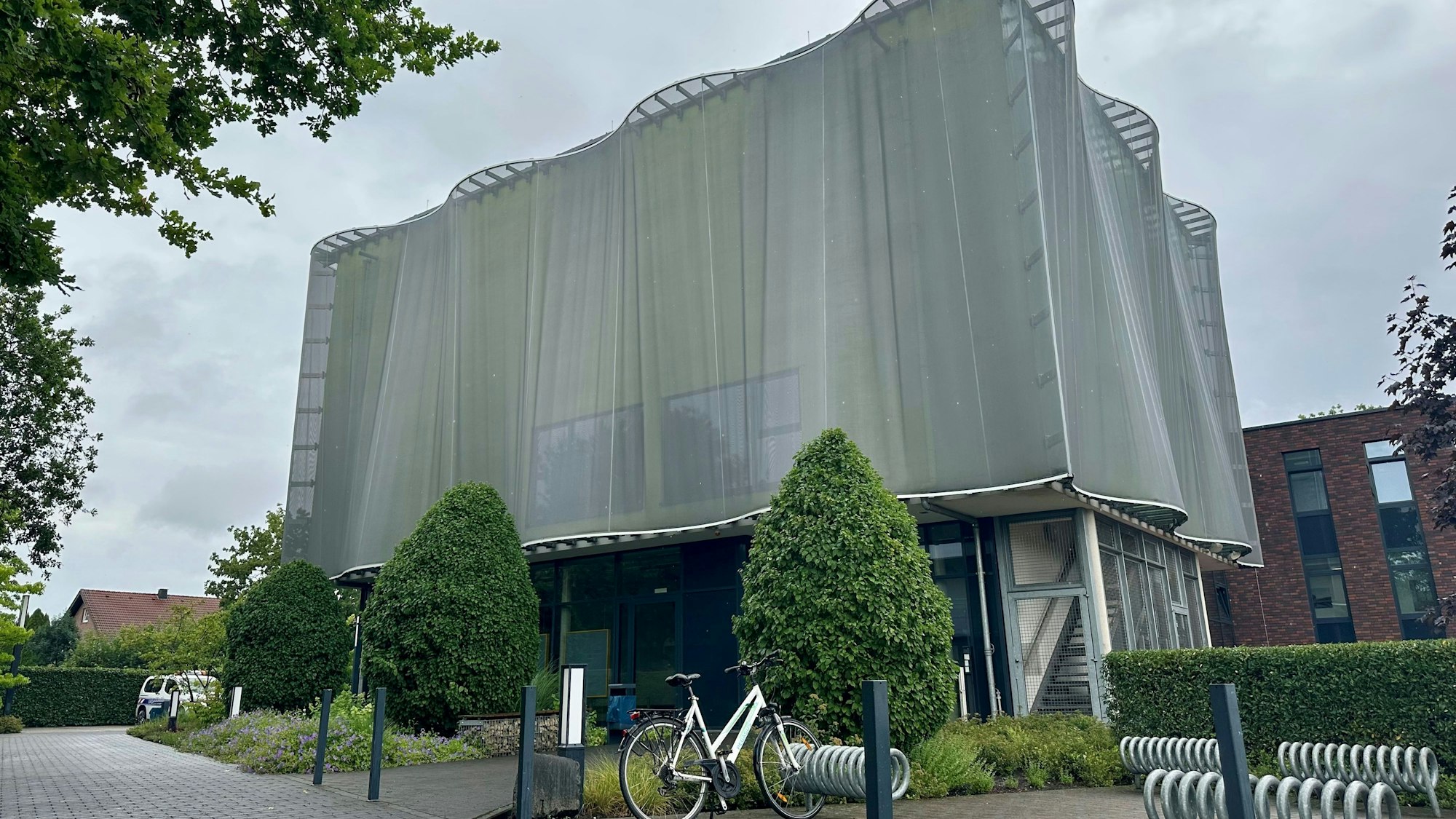 Zu sehen ist ein Gebäude, das wirkt, als wäre es von einem grauen eisernen Umhang verdeckt.