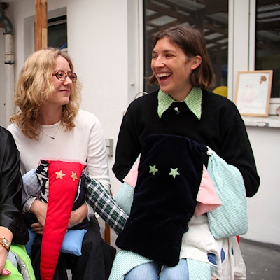 Drei Frauen stehen nebeneinander und Kuscheltiere in den Händen