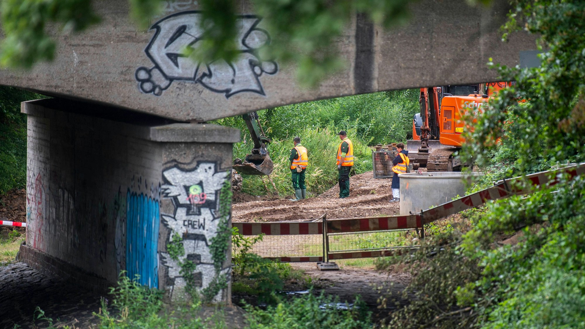 Arbeiter stehen an der Baustelle an der Erft.