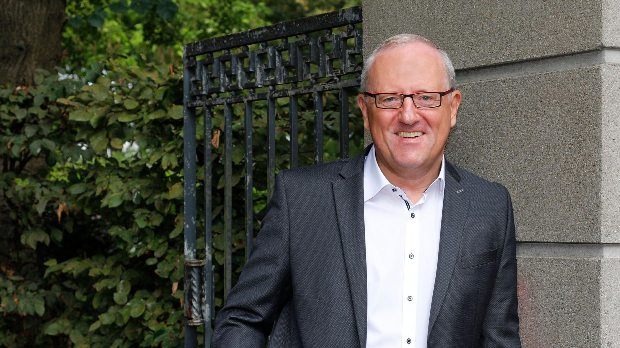 Auf dem Bild ist Wolfgang Höfig in einem dunklen Anzug und weißem Hemd zu sehen.