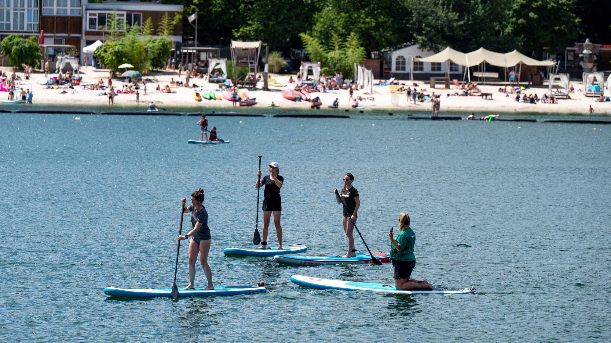 Mehrere Personen auf SUP Boards am Fühlinger See in Köln.