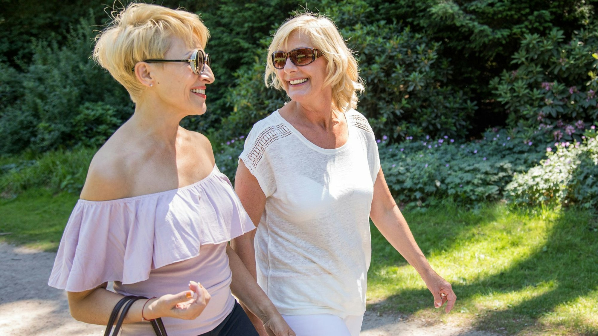 Zwei Frauen unterhalten sich bei einem Spaziergang in der Natur.