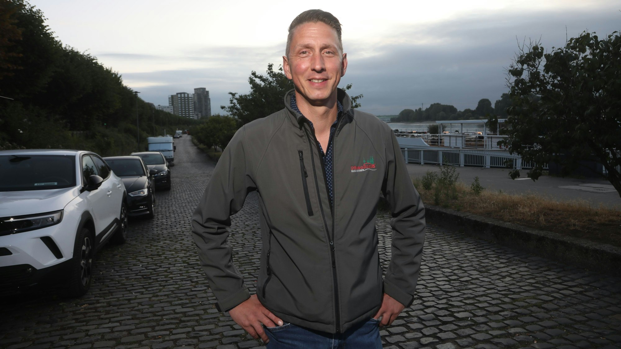 09.07.2025, Köln: Markus Klein, Inhaber des Busunternehmens Piccolonia, zeigt uns am Rheinufer, wie man mit einem Reisebus problemlos zu den Kreuzfahrtschiffen kommt. Die Stadt behauptet das Gegenteil. Foto: Arton Krasniqi