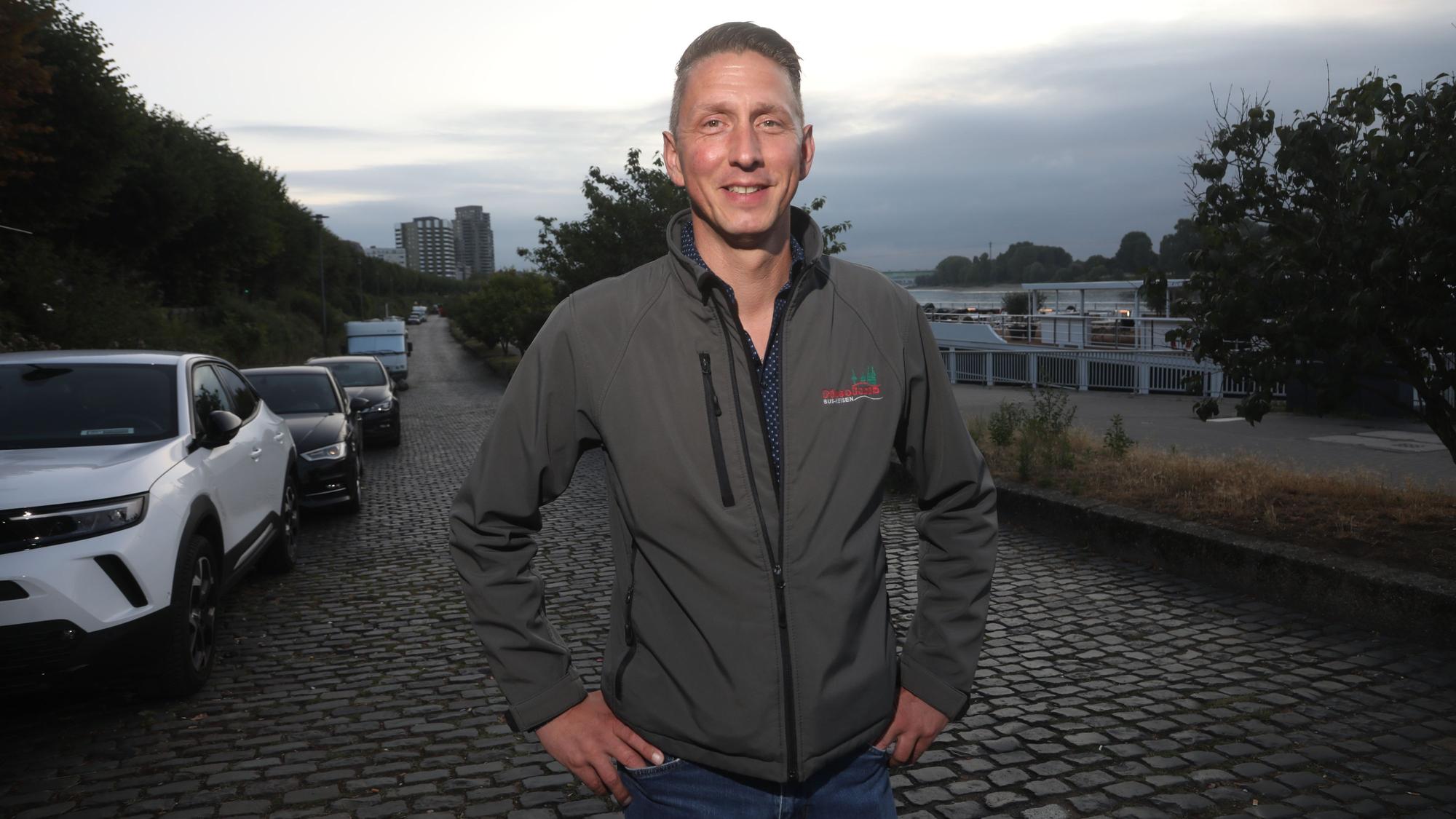 09.07.2025, Köln: Markus Klein, Inhaber des Busunternehmens Piccolonia, zeigt uns am Rheinufer, wie man mit einem Reisebus problemlos zu den Kreuzfahrtschiffen kommt. Die Stadt behauptet das Gegenteil. Foto: Arton Krasniqi