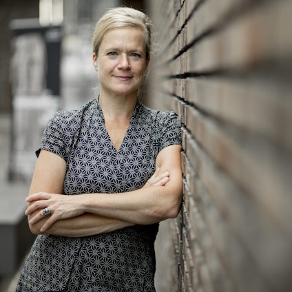 Nanette Snoep lehnt an einer Wand.