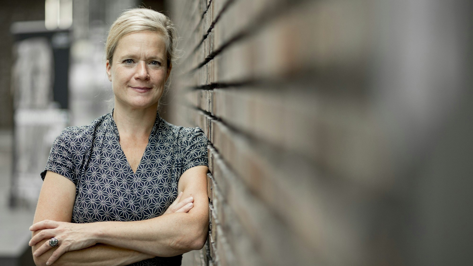 Nanette Snoep lehnt an einer Wand.