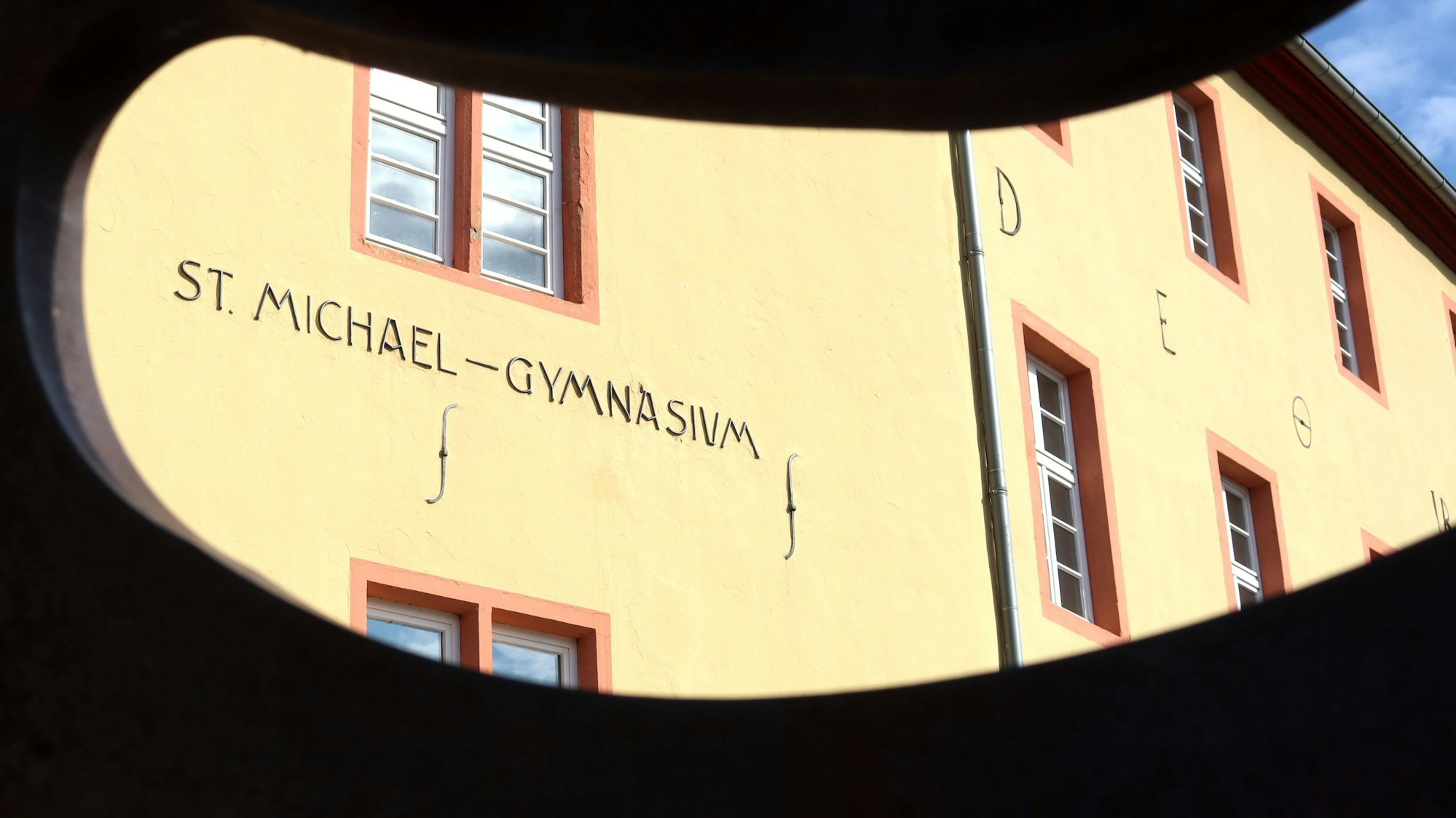 Das Gebäude des St.-Michael-Gymnasiums liegt hinter einem dunklen, umrahmten Ausschnitt.