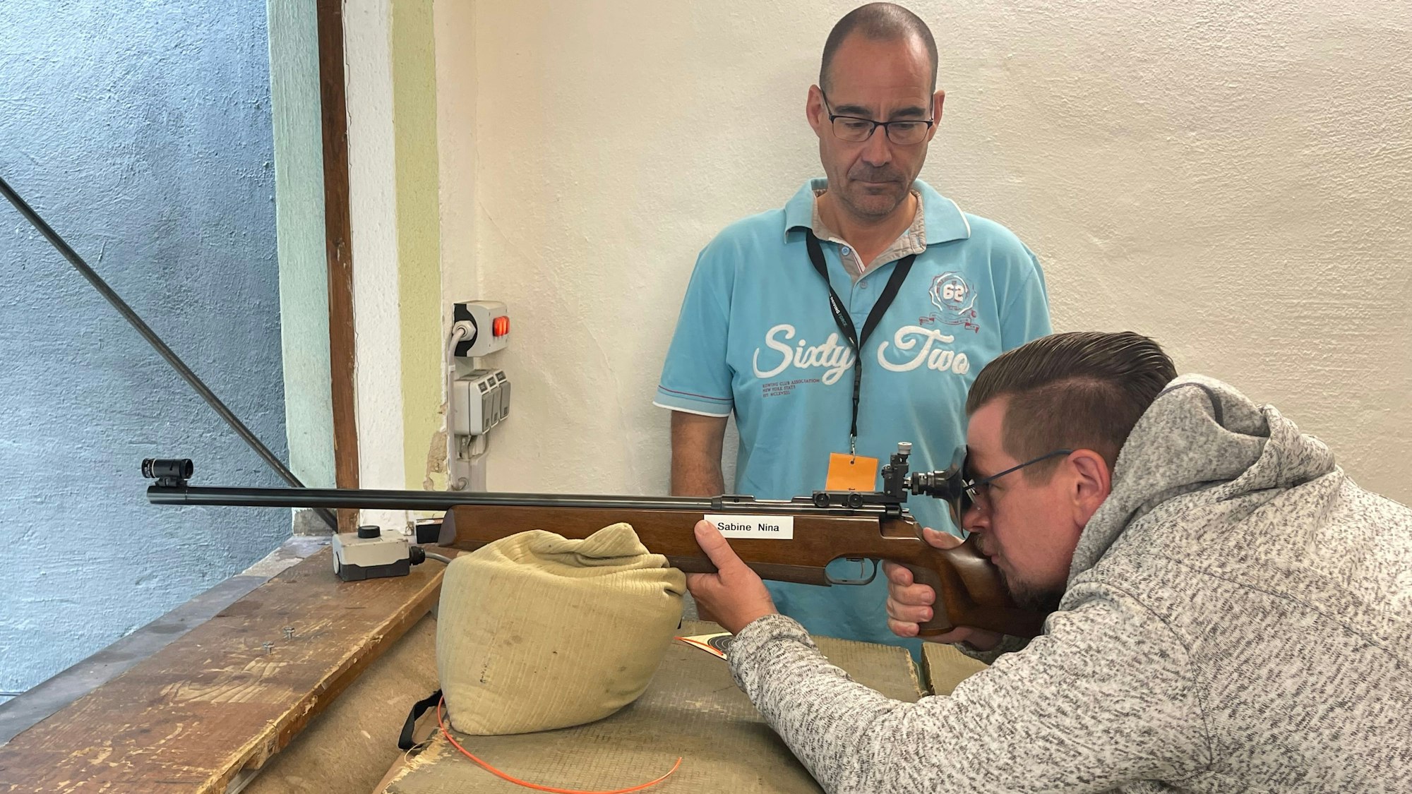 Ein Besucher schießt unter Aufsicht mit einem Kleinkalibergewehr.