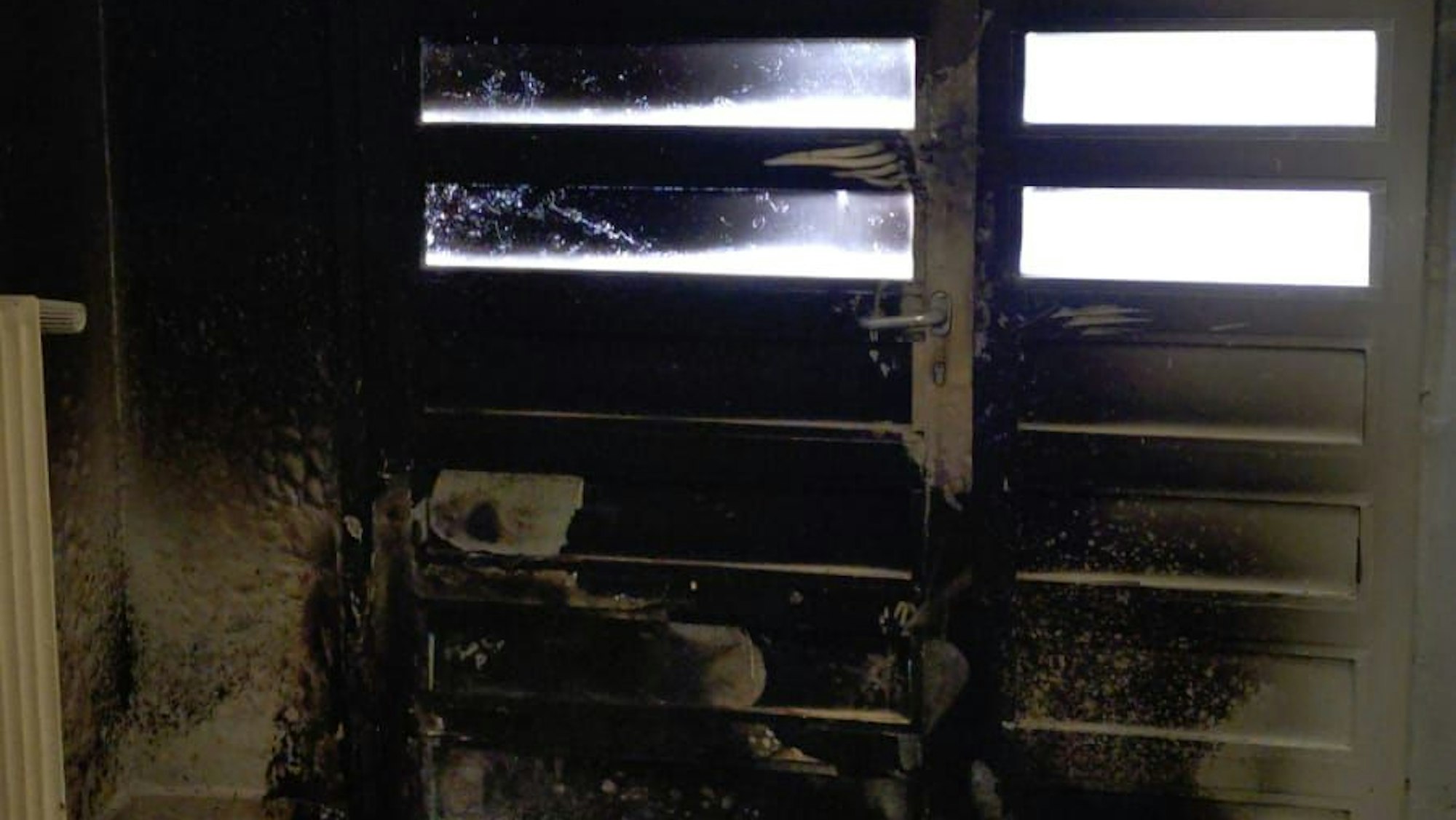 Die Eingangstür und die Innenwände des Tagestreffs sind schwarz vor Ruß.