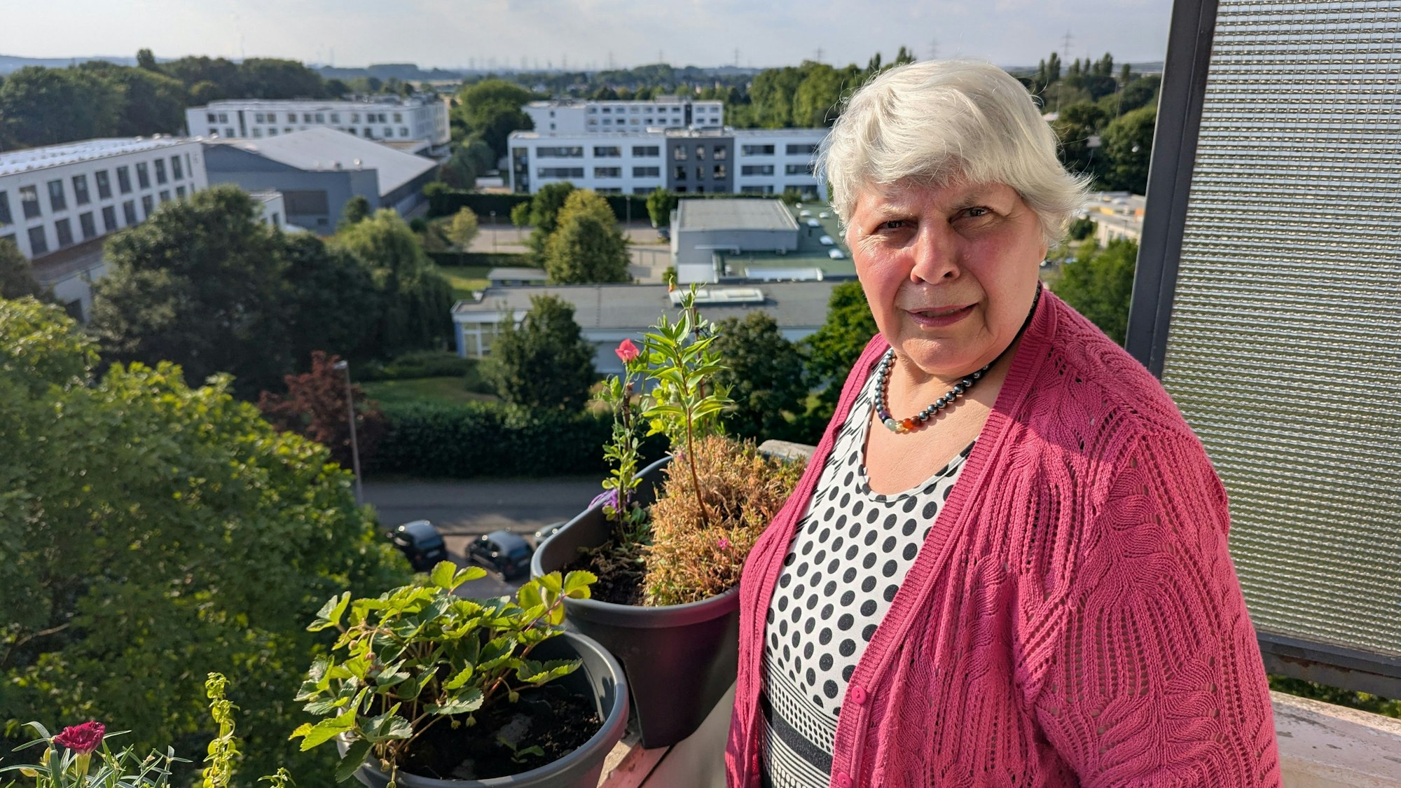 Das Foto zeigt eine Frau auf dem Balkon ihre Wohnung.