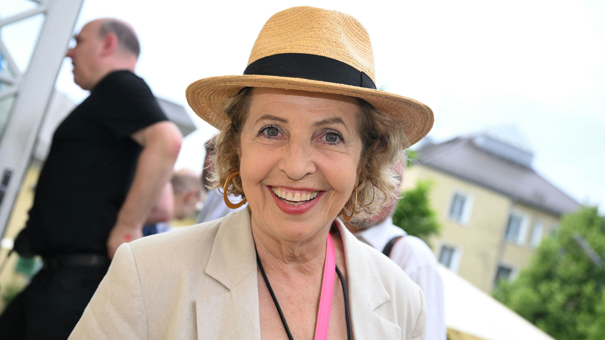 Eine Frau mit Hut lächelt in die Kamera.