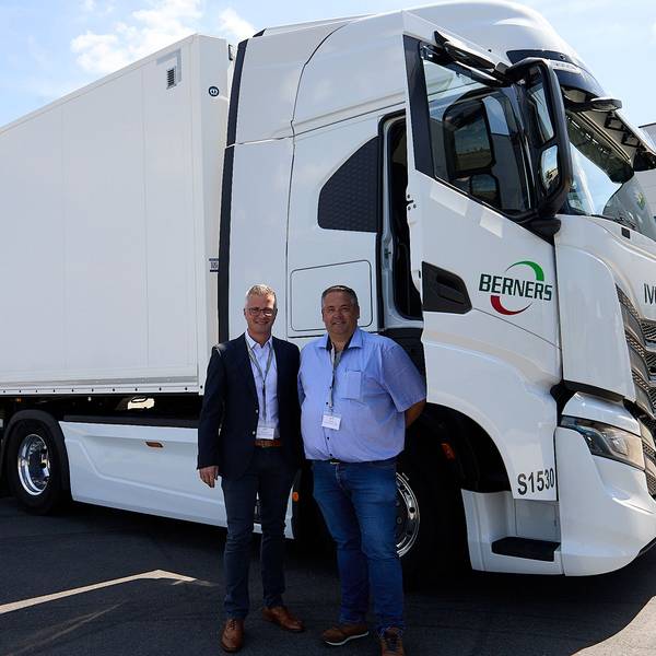 Zwei Männer stehen vor einem E-Truck, dessen Beifahrertür geöffnet ist.