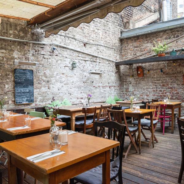 Die Terrasse im Hof eines Kölner Restaurants mit urigem Flair.