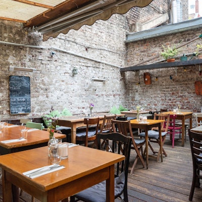 Die Terrasse im Hof eines Kölner Restaurants mit urigem Flair.