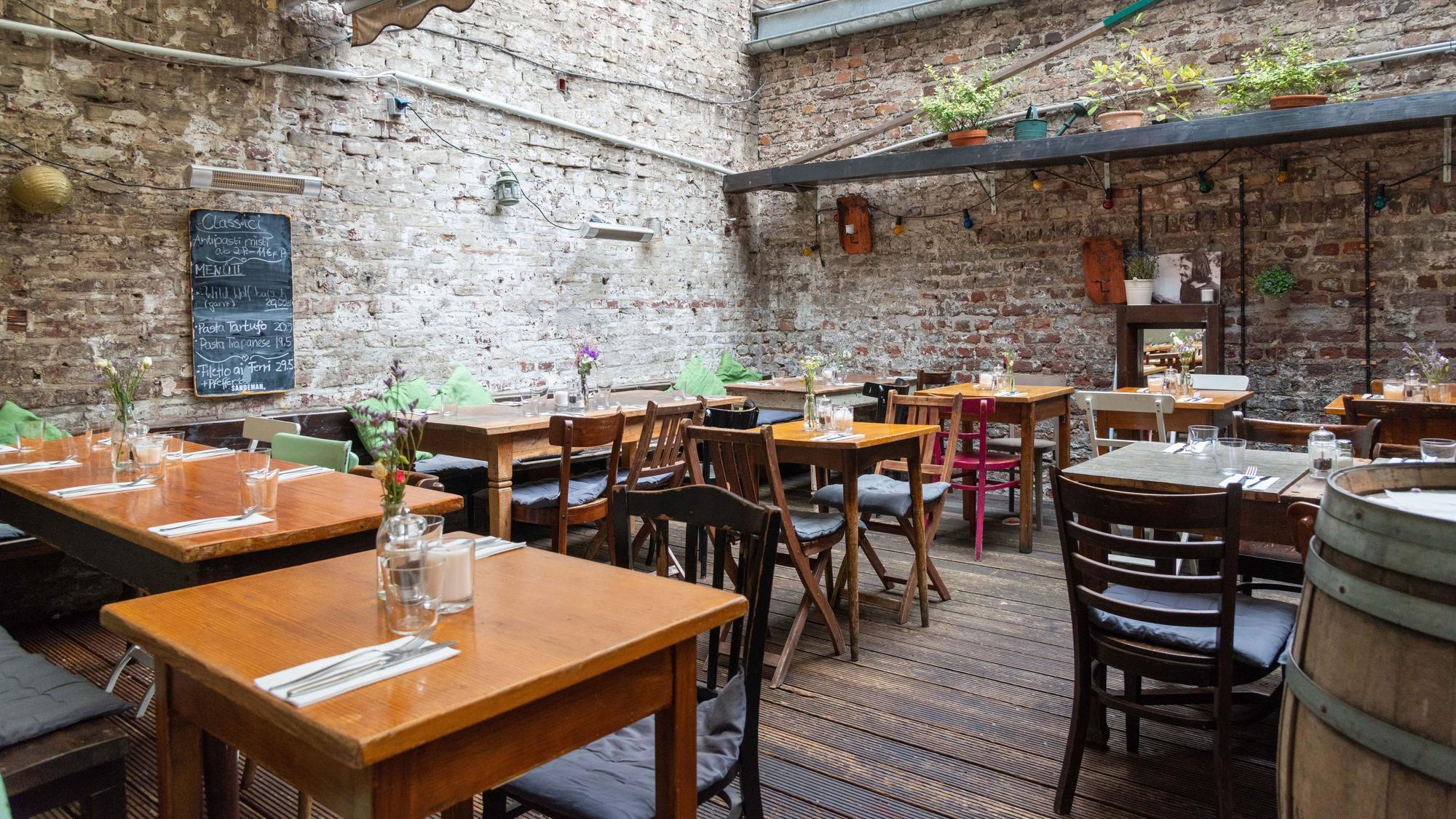 Die Terrasse im Hof eines Kölner Restaurants mit urigem Flair.
