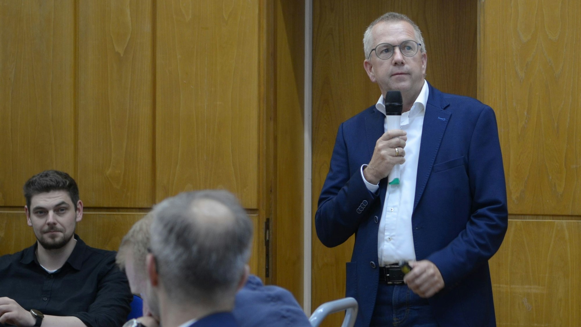 Das Bild zeigt Heiko Wollmann mit einem Mikrofon in der Hand.