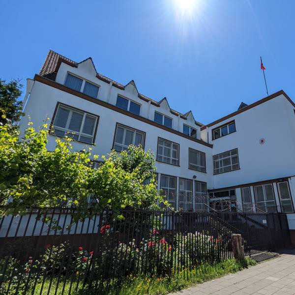 Ein großes Gebäude mit Türkei-Flagge auf dem Dach ist bei strahlendem Wetter zu sehen.