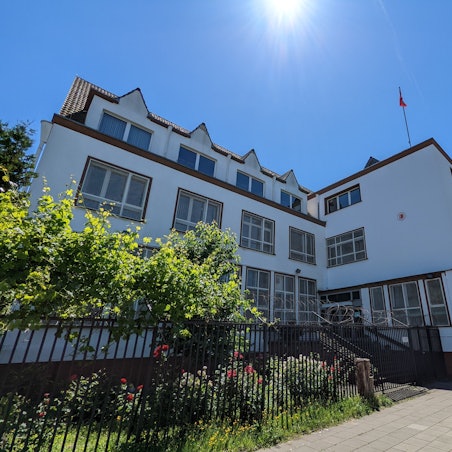 Ein großes Gebäude mit Türkei-Flagge auf dem Dach ist bei strahlendem Wetter zu sehen.