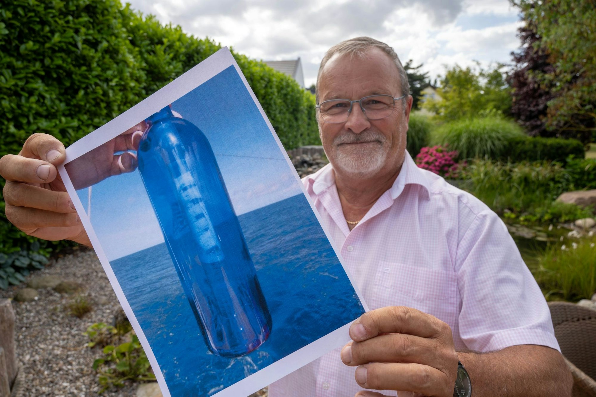 Jörg Wanke zeigt ein Foto seiner Flaschenpost.