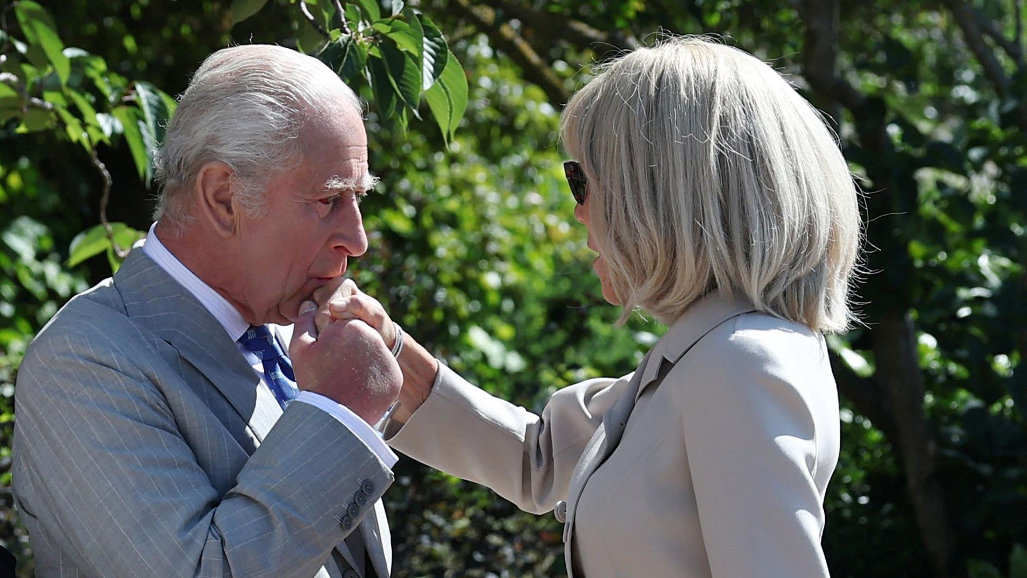 König Charles gibt Brigitte Macron einen Handkuss.